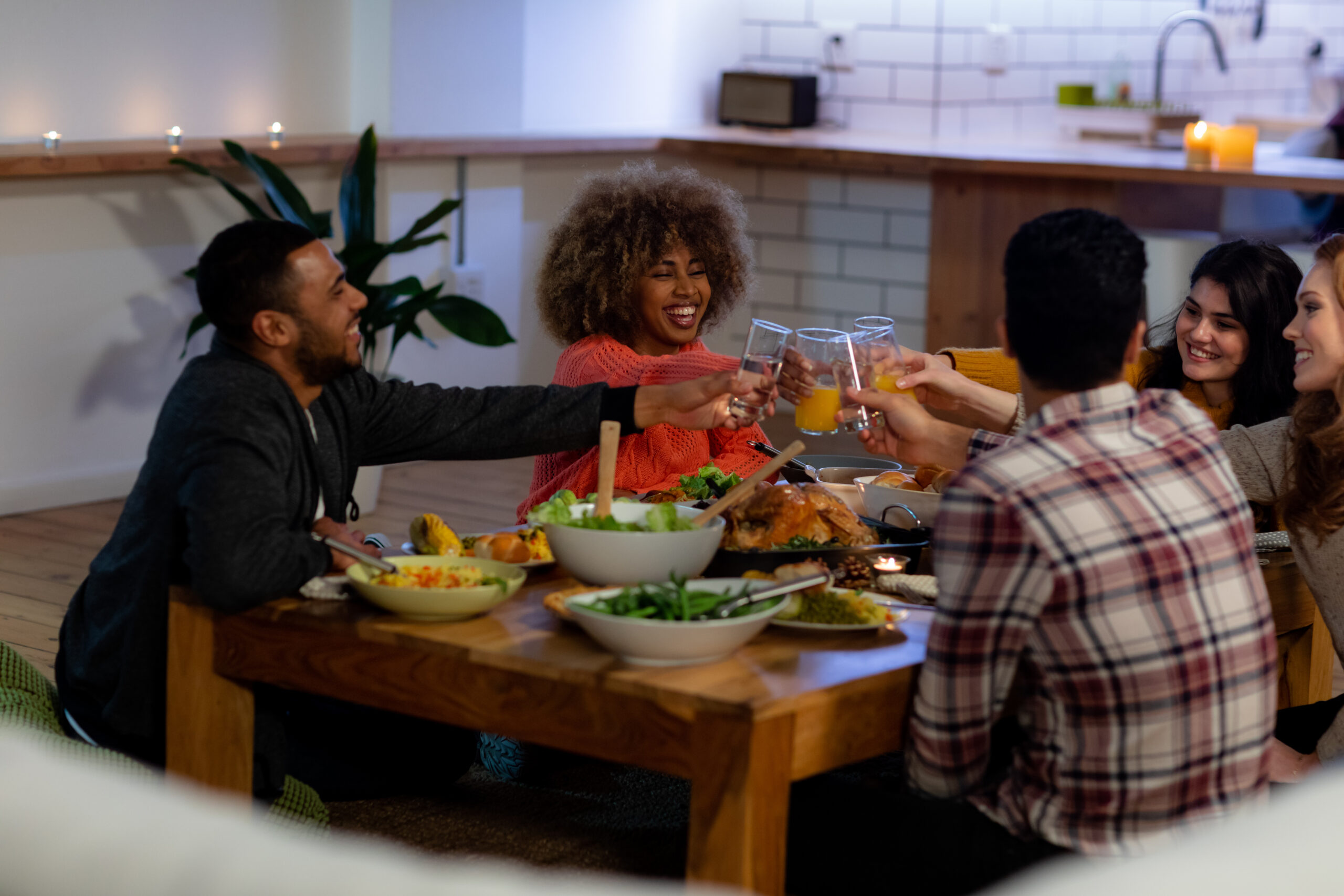 millennials sharing meal together sitting at coffee table in apartment